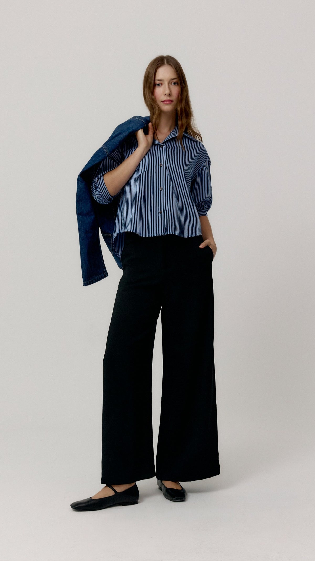 Pantalón Edmond negro de Biscuit en look frontal con camisa de rayas